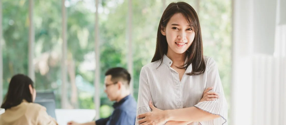 Confident leader standing with arms folded, representing calm, grounded leadership in the workplace