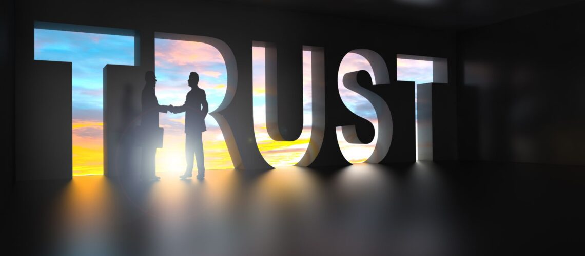 Silhouettes shaking hands through bold TRUST lettering, symbolising integrity and influence