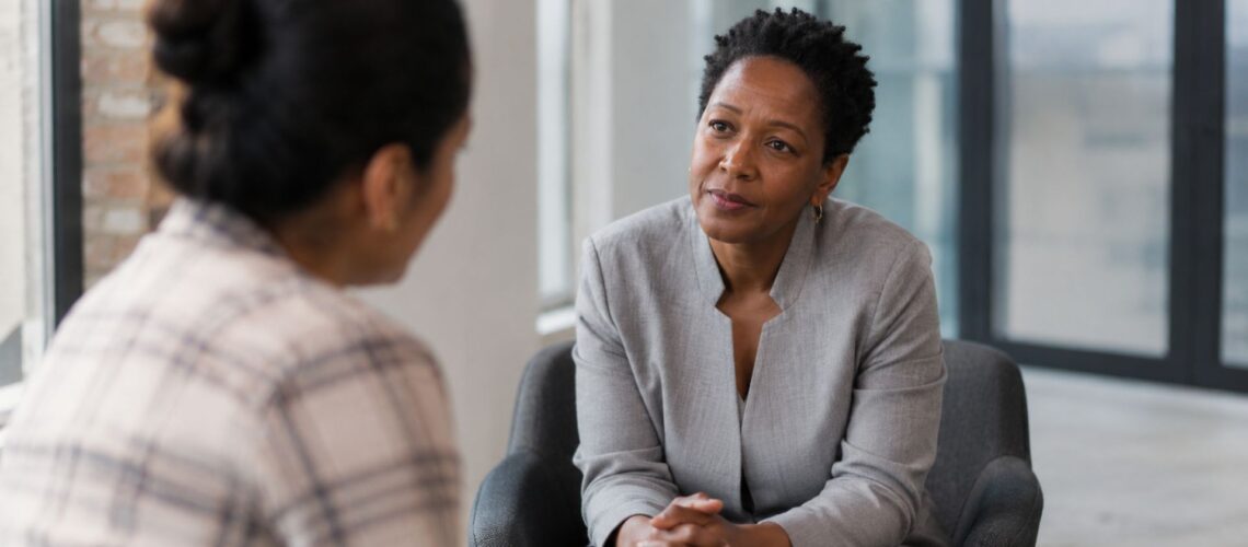 A leader listening attentively during a one-to-one conversation in a calm, naturally lit workspace