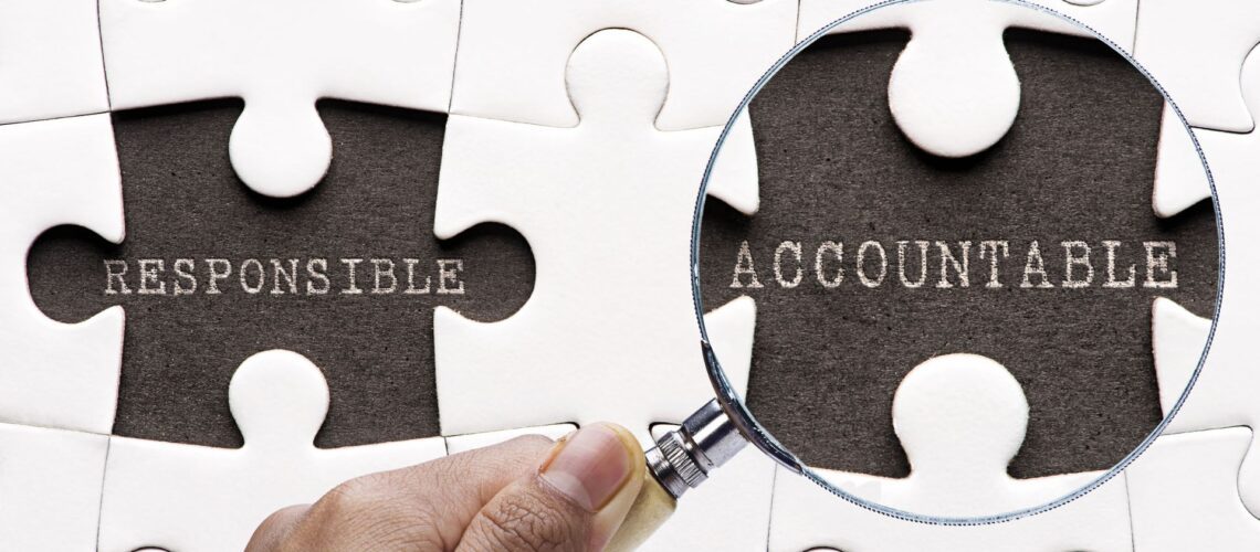 Puzzle pieces showing 'Responsible' and 'Accountable' with magnifying glass highlighting the difference between accountability vs responsibility in teams