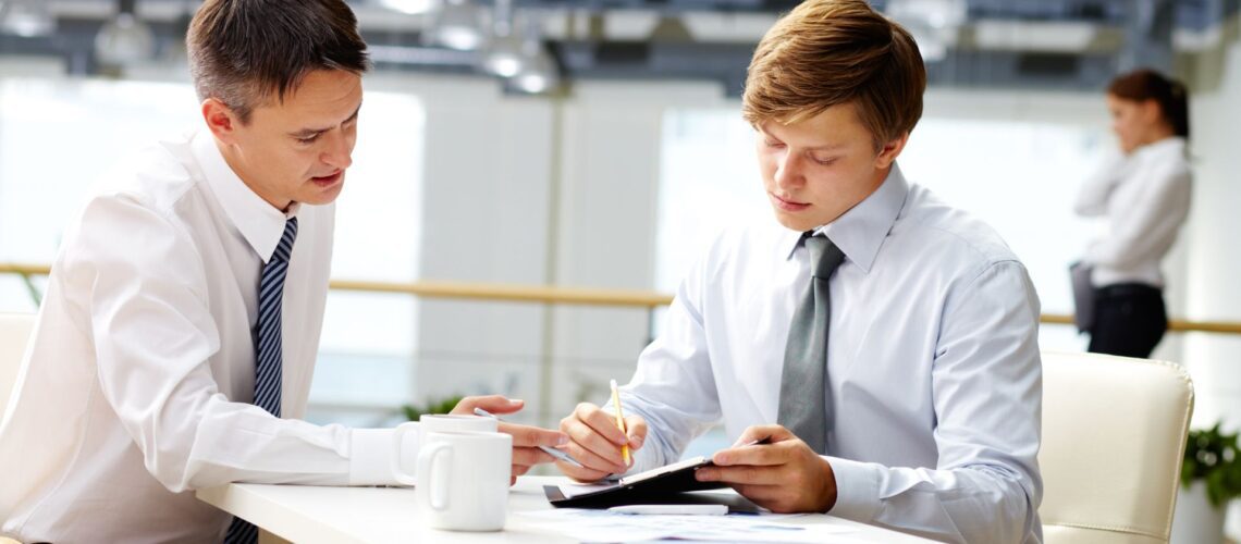 Professional manager coaching employees in modern office environment during team meeting