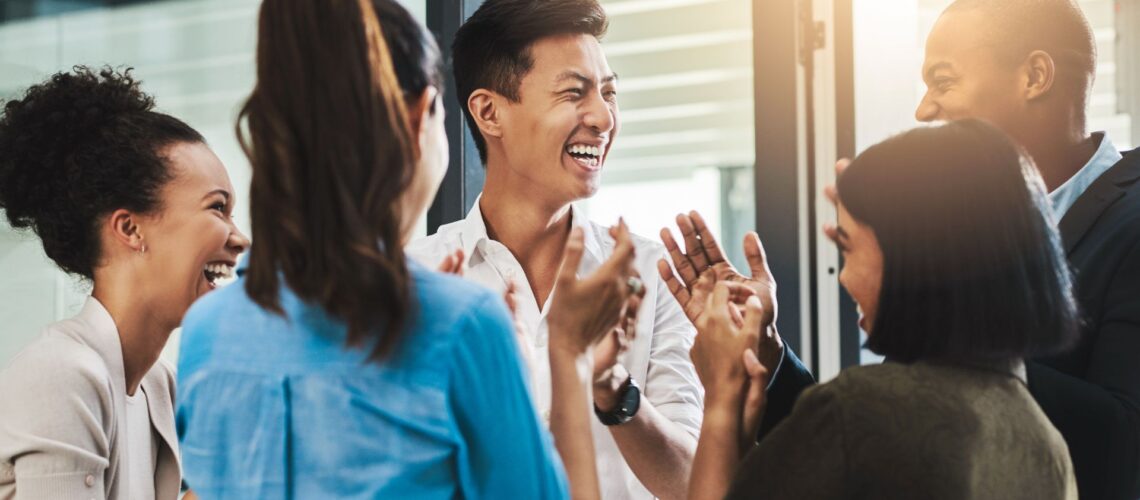 Diverse team of professionals celebrating success with high-fives showing workplace motivation and engagement