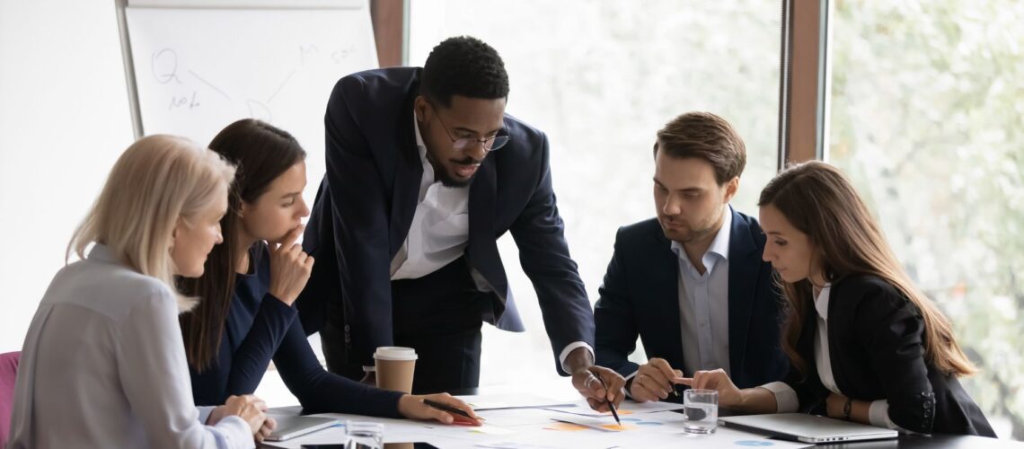 Diverse business team collaborating in meeting room demonstrating cross-functional leadership without formal authority