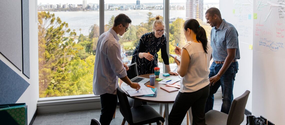 Senior professionals collaborating in a modern office, representing leadership in science and technology sectors