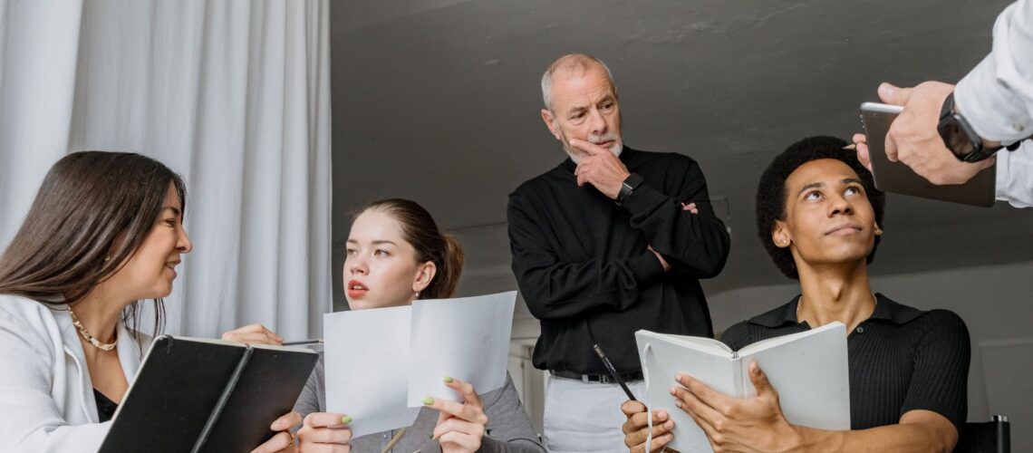 Diverse multigenerational technology team collaborating in modern office meeting room