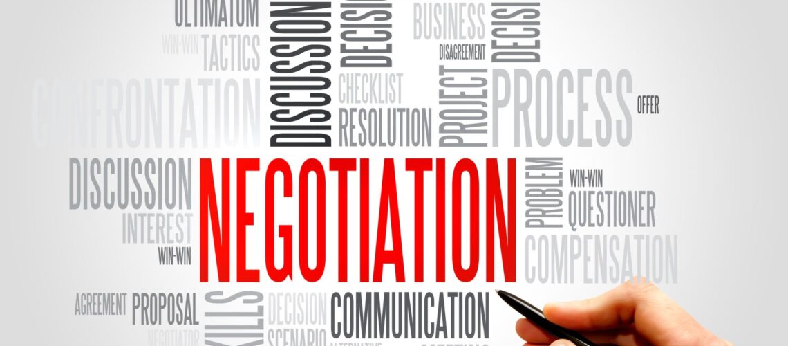 Negotiation word cloud featuring key terms like communication, win-win, and discussion with hand holding pen