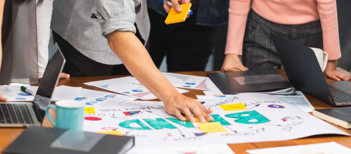 Business professionals collaborating on personal brand strategy with charts and sticky notes in modern office