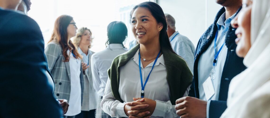 Confident professional woman networking at business conference, building personal brand connections