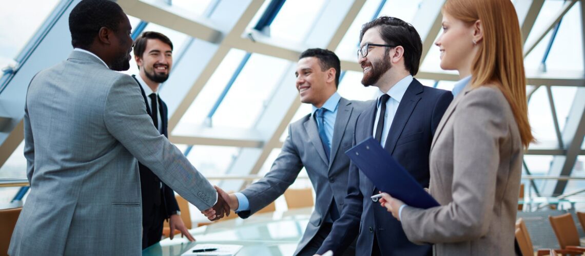Technical leaders shaking hands after successful negotiation in modern office