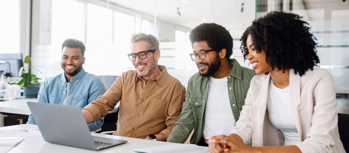 Diverse cross-functional teams working together in modern office environment demonstrating collaborative leadership skills