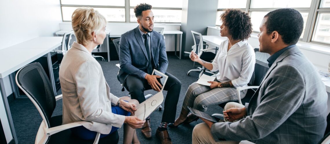 Diverse business professionals in supportive team meeting discussing change management strategies in modern office environment