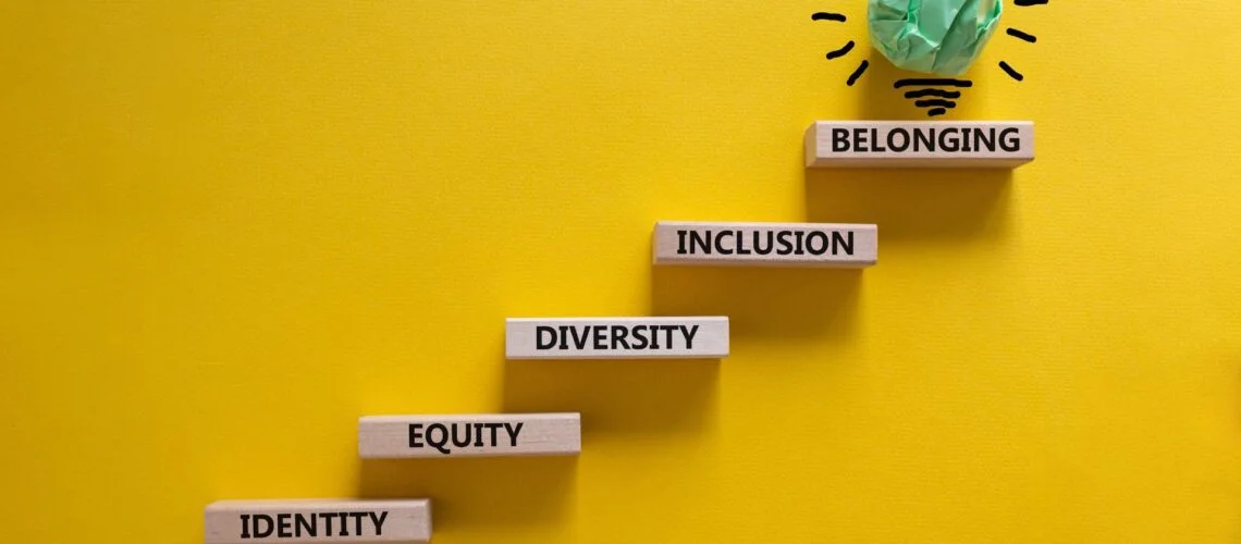 Wooden blocks displaying diversity, inclusion, belonging and equity concepts with lightbulb representing innovation
