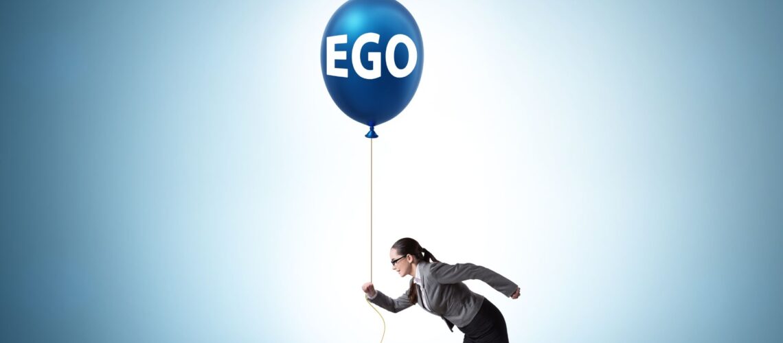 Business professional being lifted by inflated ego balloon symbolising arrogance in leadership