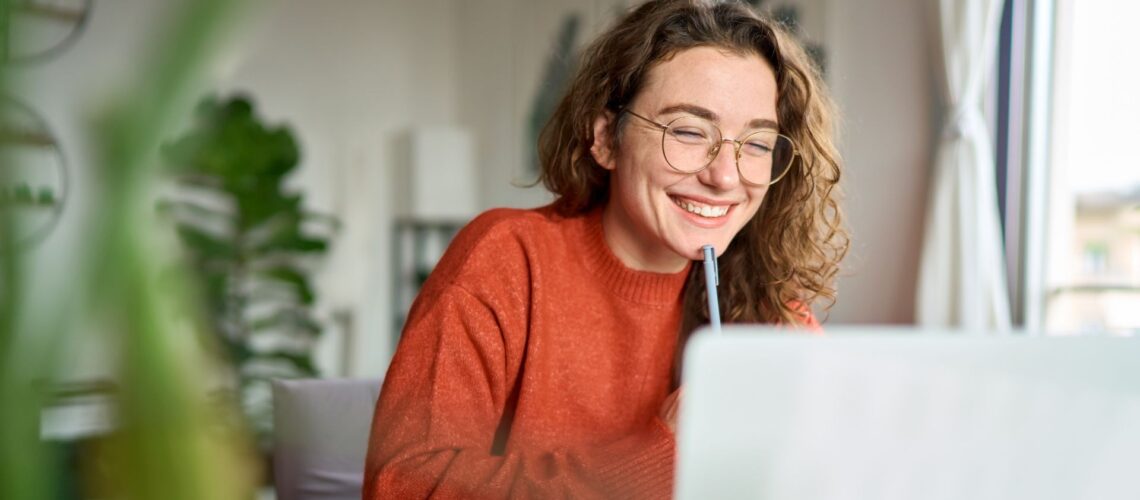 Professional woman smiling while working remotely from home office, representing successful hybrid working