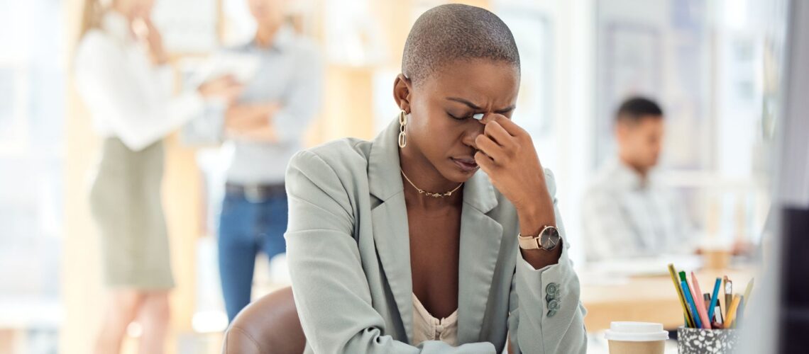 Professional woman showing signs of workplace stress and burnout in office environment