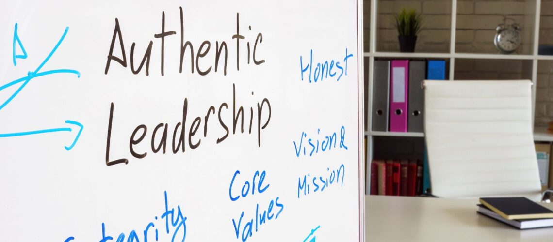 Leadership concepts including authenticity, vision, and core values displayed on office whiteboard