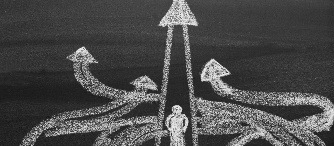 Aerial view of person at crossroads with multiple directional arrows symbolising leadership decisions during change
