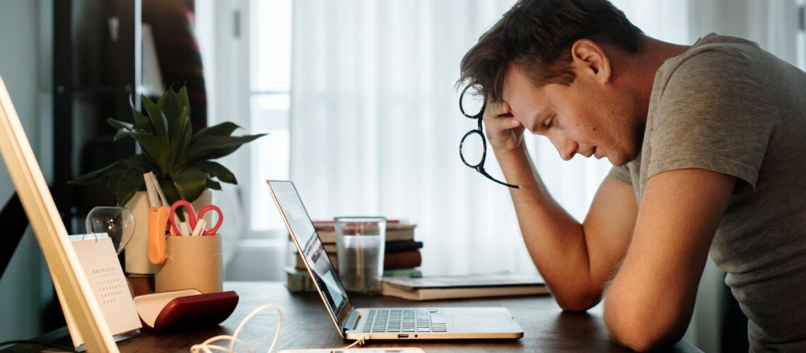 Overwhelmed professional experiencing workplace distress and bad stress at desk