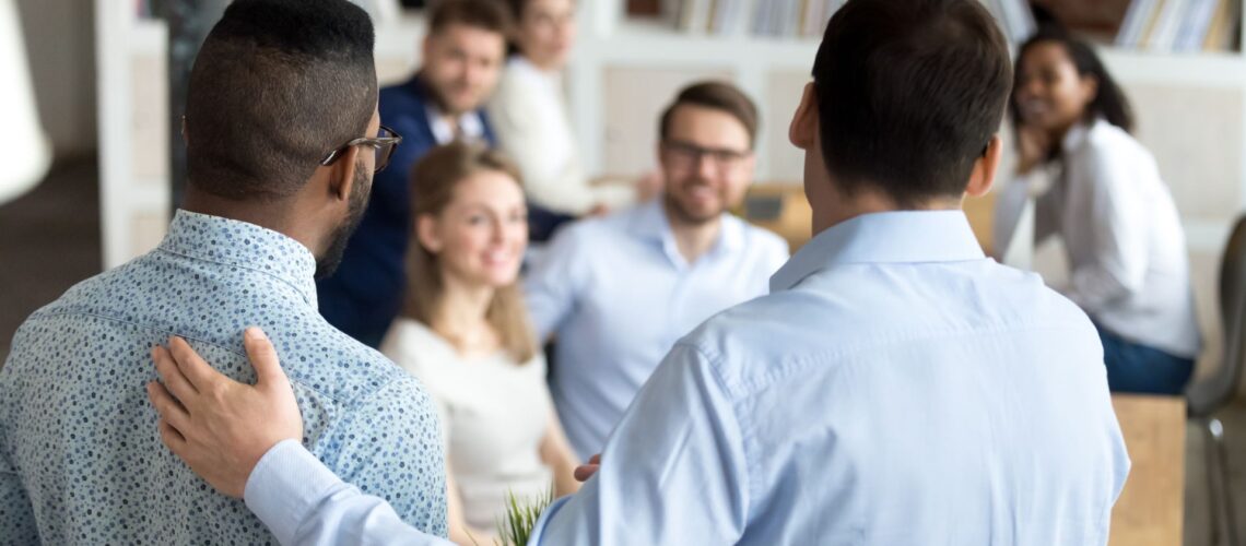 Professional leader providing supportive guidance to team member in collaborative workplace environment