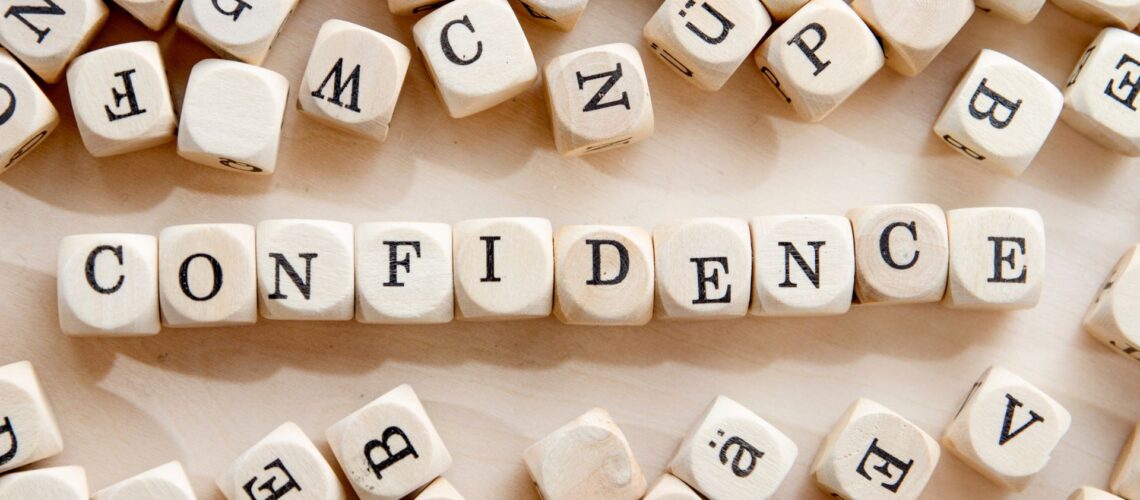 Wooden letter blocks spelling confidence representing leadership skill development and building workplace confidence